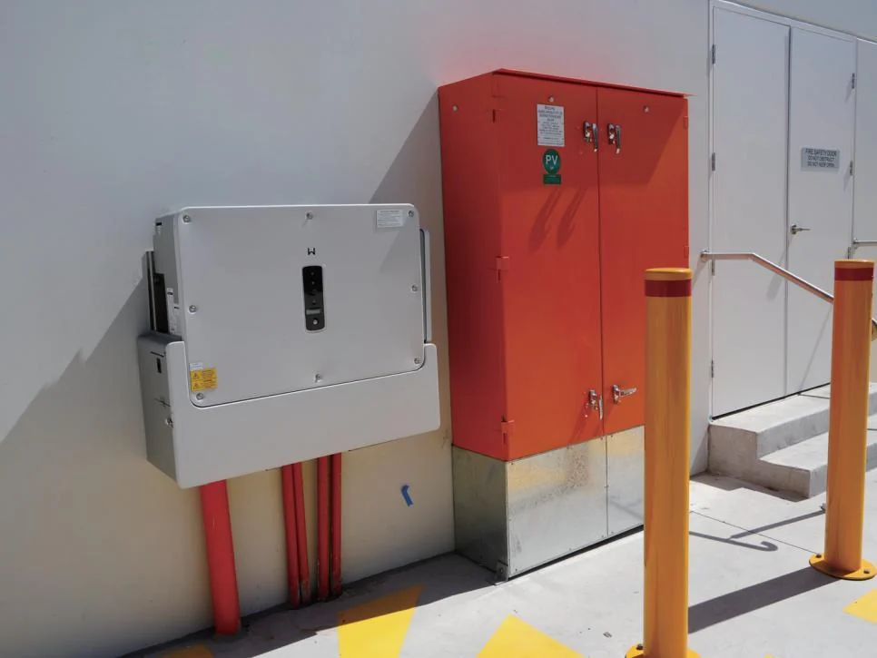 GoodWe three-phase string inverter wall-mounted beside the switchboard