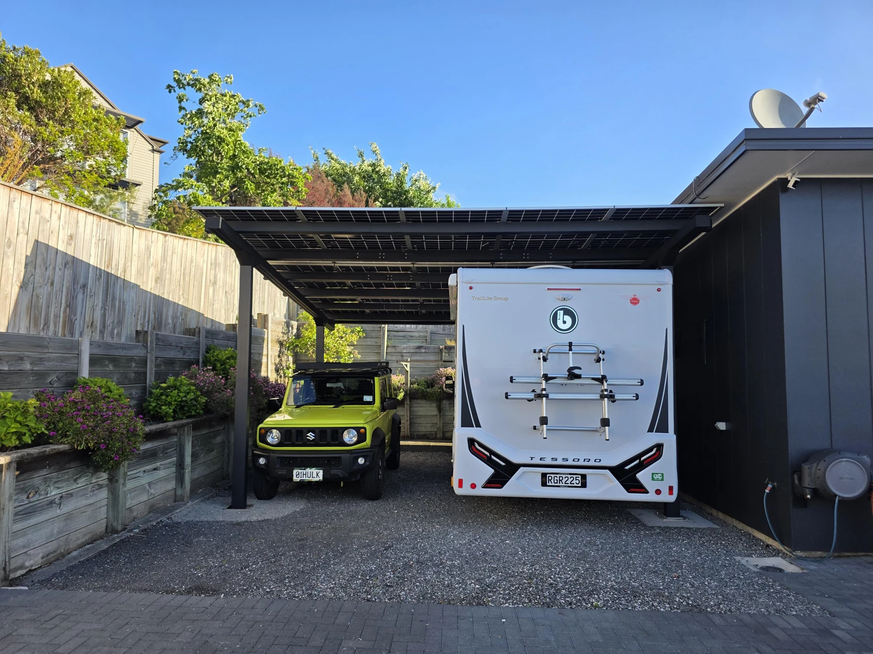 The RV and a second vehicle parked beneath the canopy.